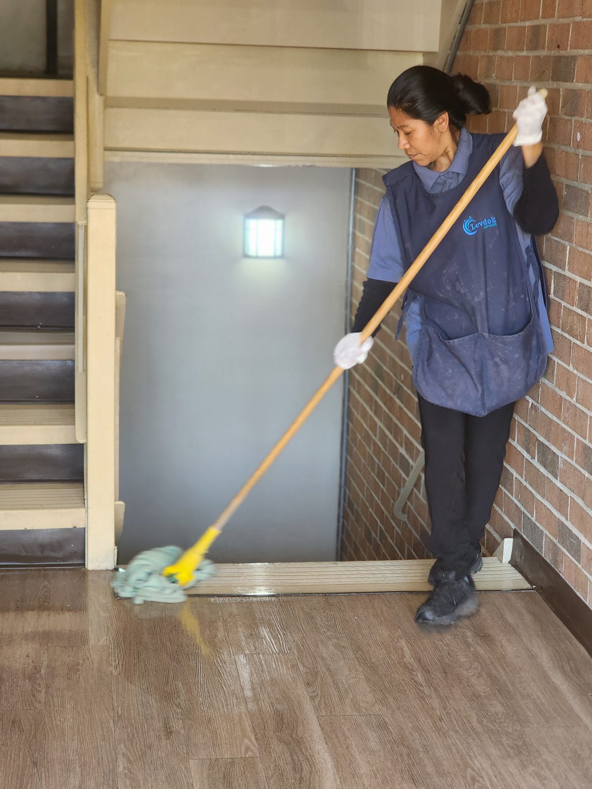 Levdok team member mopping a common-area entryway at a Baltimore apartment community