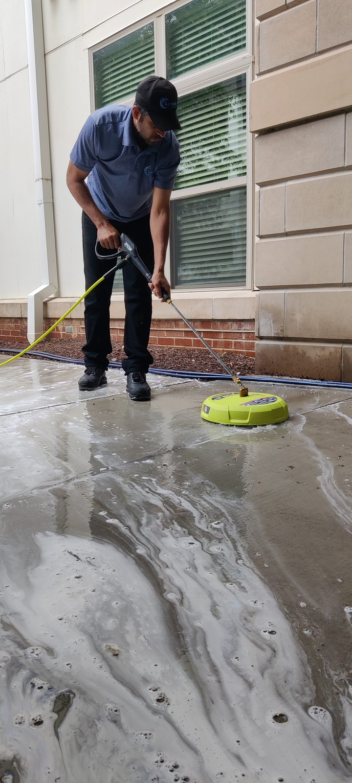Levdok technician pressure washing a concrete patio in Baltimore, MD